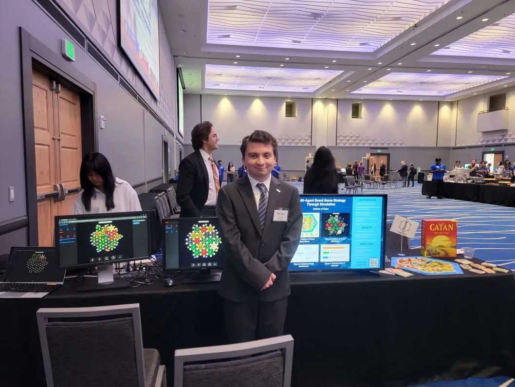 Brian standing in front of Team Tactica's table at IPPD's FDR event.