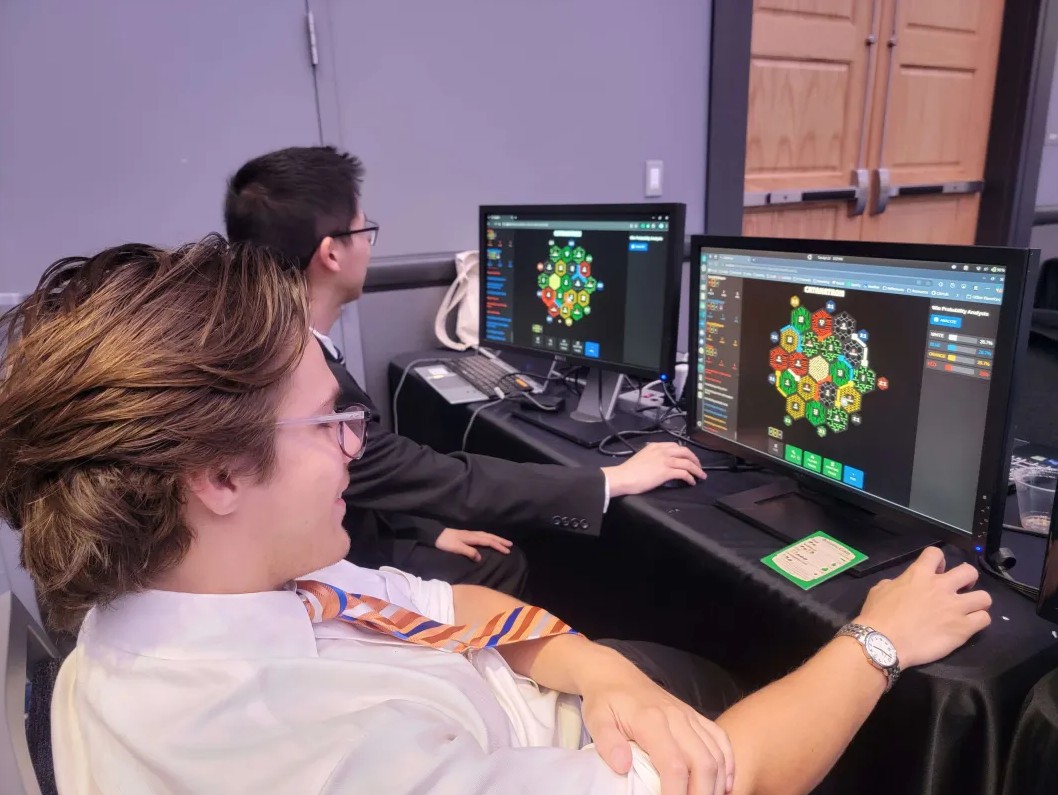 Tactica team members Jason and Max playing Catan at IPPD's FDR event.